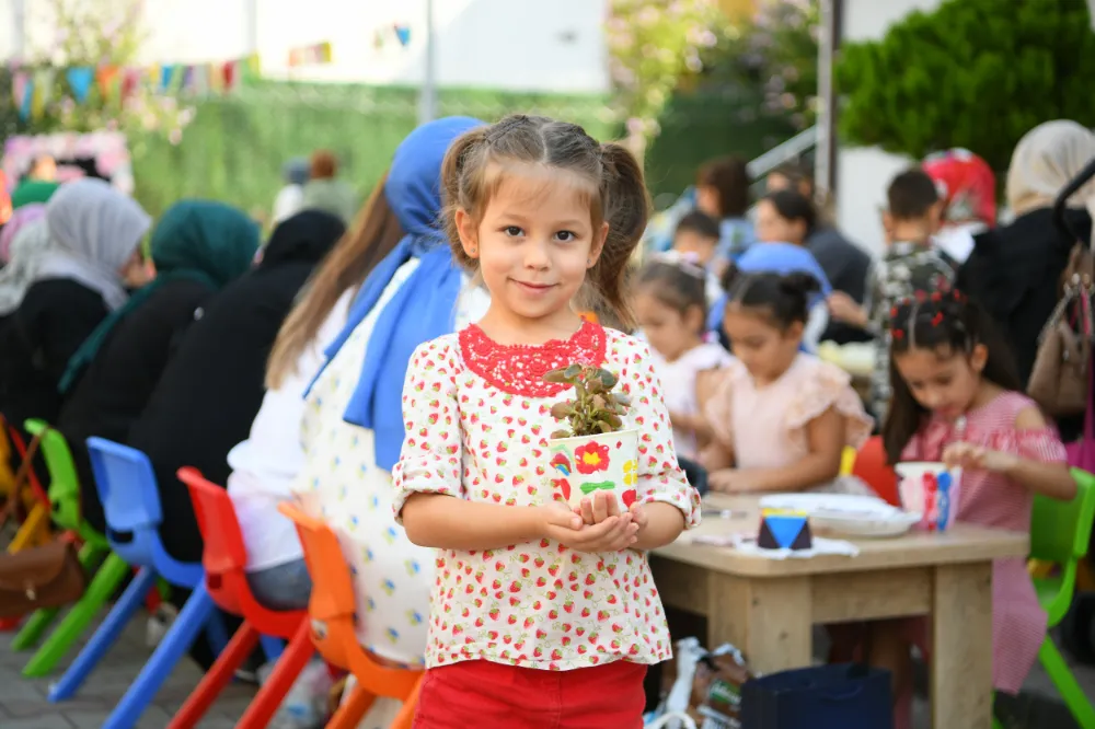 Aileler ve çocuklar, birlikte saksı boyayıp çiçek ekti